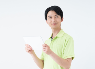 介護服を着た男性がバインダーを持っている画像